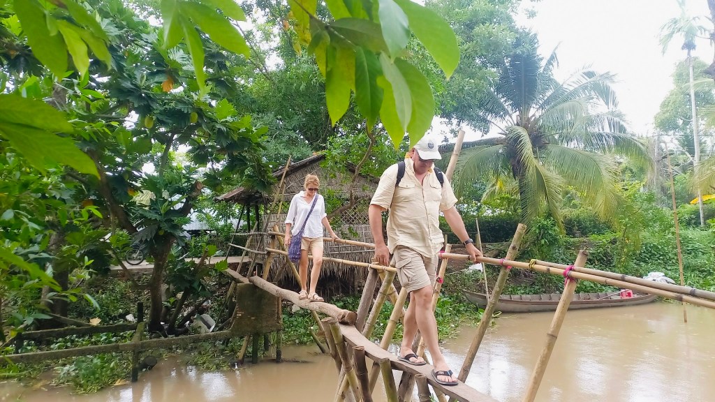 Tourists crossing a traditional monkey bridge on Son Islet, Can Tho, Vietnam. A unique experience in the Mekong Delta.