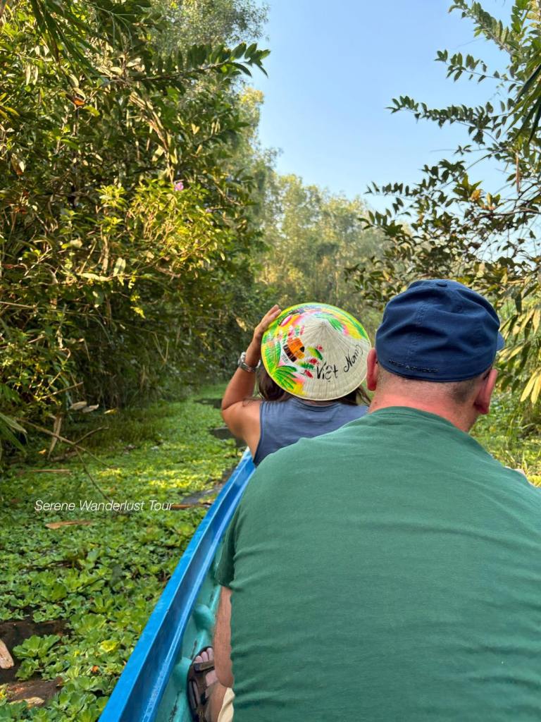 Tourists taking a relaxing boat ride through the lush green waterways of Lung Ngoc Hoang Nature Reserve.