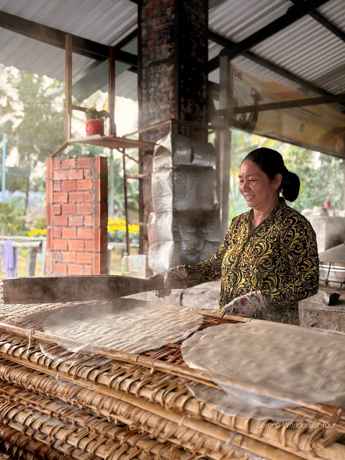 Freshly made Vietnamese rice paper drying on bamboo trays under the sun in Can Tho.