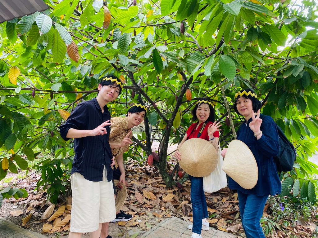 Tourists enjoying a visit to a local cacao garden, learning about the chocolate-making process.